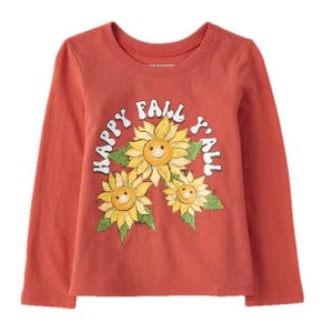 A long-sleeved orange shirt featuring three smiling sunflowers and the phrase \“Happy Fall Y'all\“ in white letters on the front.