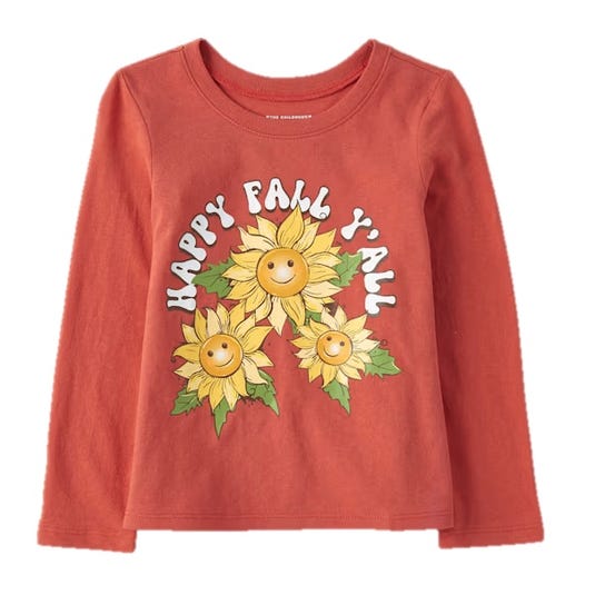 A long-sleeved orange shirt featuring three smiling sunflowers and the phrase \“Happy Fall Y'all\“ in white letters on the front.