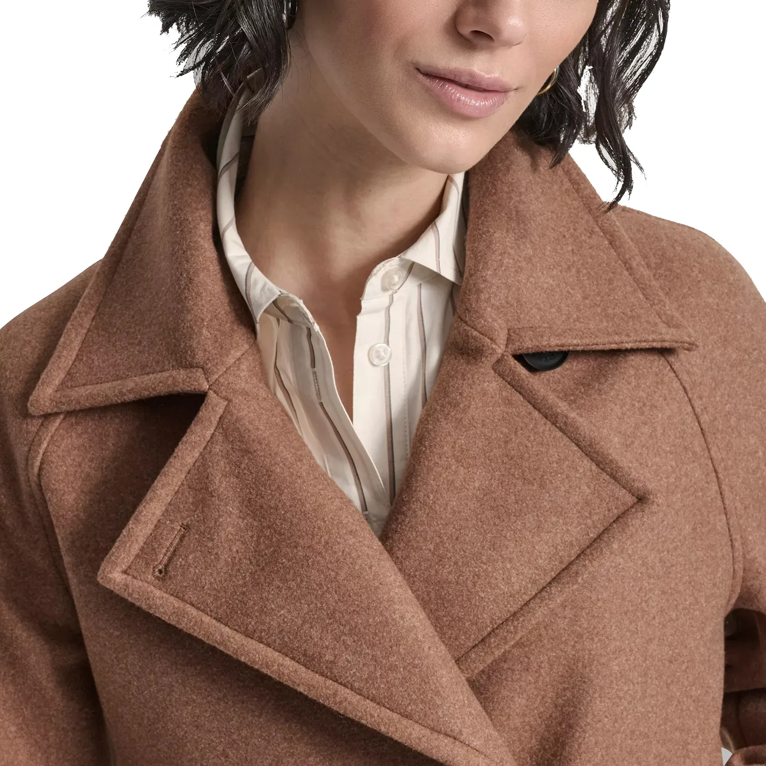 A woman wearing a brown wool coat over a white button-up shirt with subtle stripes, featuring a wide lapel and one visible button detail.