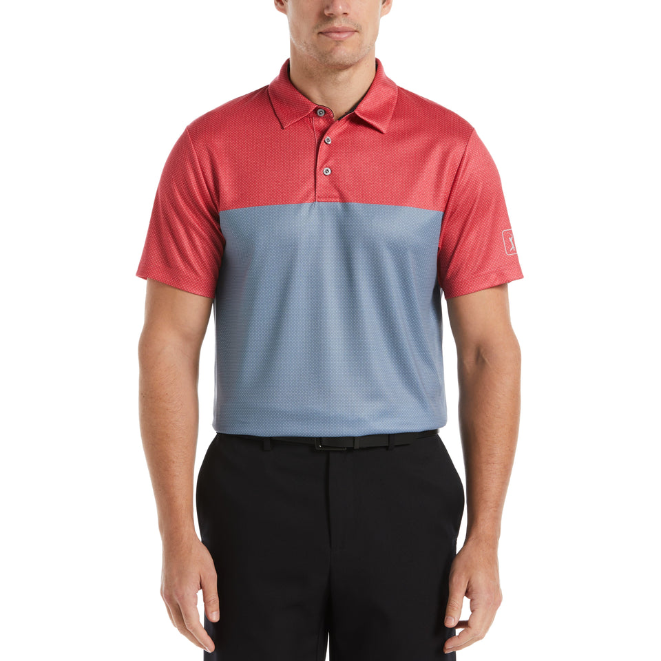 A man wearing a color-blocked polo shirt with red on the top and blue on the bottom.