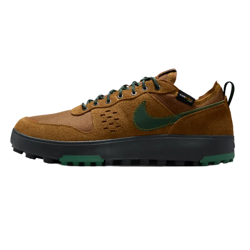 Nike sneaker with brown and green accents, featuring a suede and mesh upper, green swoosh, rugged outsole, and black midsole.