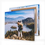 Canvas art prints featuring a person overlooking a scenic lake and island landscape, backed by mountains and partially obscured by another canvas frame.