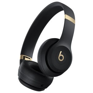 Black over-ear wireless headphones with gold accents, featuring the signature \“b\“ logo.