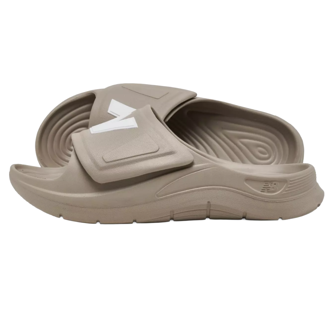 Beige slide sandals with a prominent white \“N\“ logo on the strap, featuring a textured footbed and grooved sole for comfort and grip.