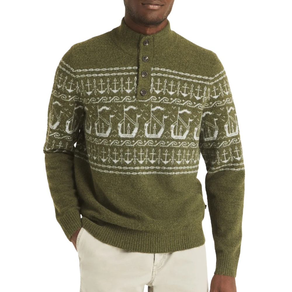 Olive green sweater with a Nordic-inspired pattern featuring ships and anchors, a button-up collar, ribbed cuffs, and hem paired with light beige pants.