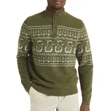 Olive green sweater with a Nordic-inspired pattern featuring ships and anchors, a button-up collar, ribbed cuffs, and hem paired with light beige pants.