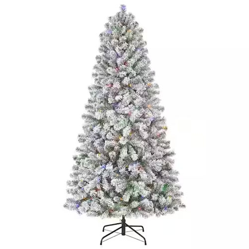 A 6.5-foot flocked artificial Christmas tree with multi-colored pre-lit lights on hinged branches, featuring a sturdy metal stand.