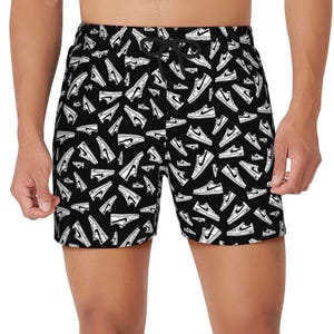 Black swim trunks with a white shoe pattern, featuring various sneaker designs.