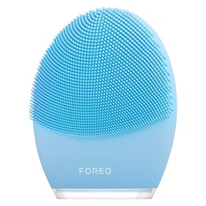 A light blue silicone facial cleansing brush with small bristles, labeled \“FOREO.\“