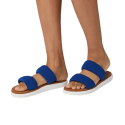 Blue slip-on sandals with two wide straps over the foot and a white sole are shown on a person standing.