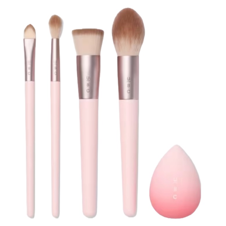 A set of four pink-handled makeup brushes and a pink blending sponge.