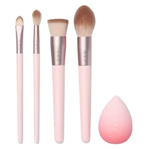 A set of four pink-handled makeup brushes and a pink blending sponge.