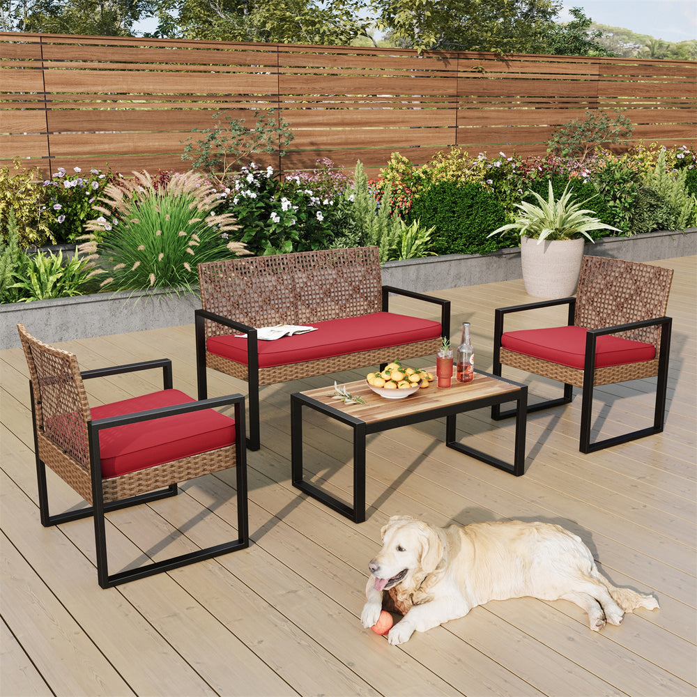 Outdoor patio set with red cushions includes a loveseat, two chairs, and a coffee table with a wooden top, placed on a wooden deck. A dog is lying on the deck.