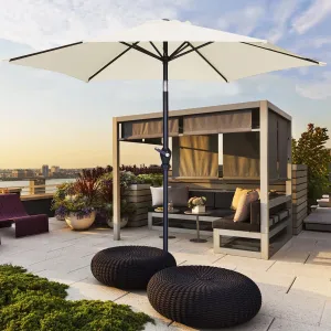 A large white umbrella with a crank mechanism and tilt function, set up over an outdoor seating area.