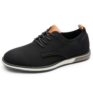 A black lace-up casual shoe with a knit texture, featuring a tan leather accent at the tongue and heel. The sole is white with a brown section, providing a modern, versatile look.