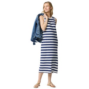 A blue and white striped sleeveless maxi dress paired with gold sandals and a denim jacket draped over the shoulder.