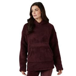 A woman is wearing a burgundy, plush sherpa hoodie with a front kangaroo pocket and relaxed fit.