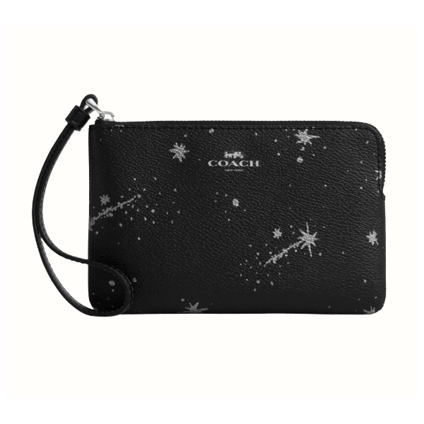 A black Coach wristlet with a celestial pattern of stars and comets, featuring a zip closure and a small strap for carrying.