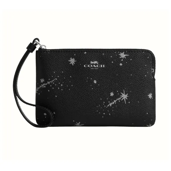 A black Coach wristlet with a celestial pattern of stars and comets, featuring a zip closure and a small strap for carrying.