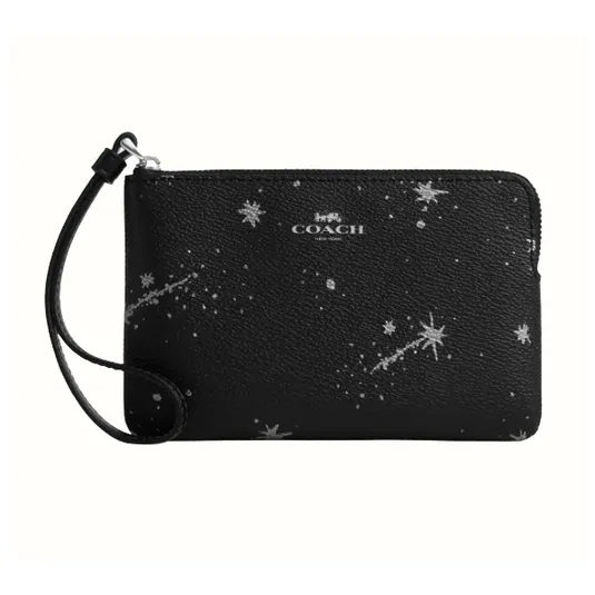 A black Coach wristlet with a celestial pattern of stars and comets, featuring a zip closure and a small strap for carrying.