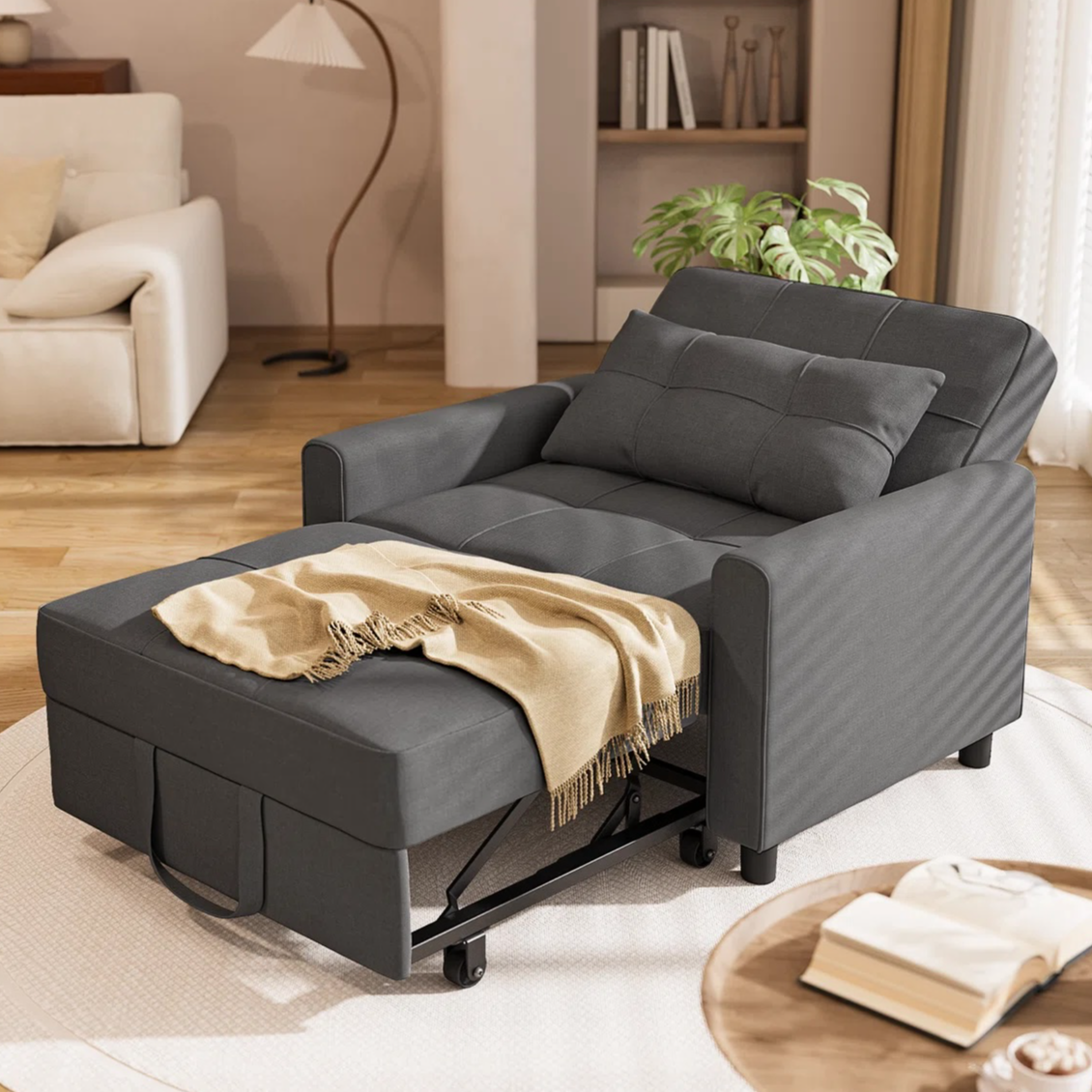 A dark gray chair with a pull-out ottoman, cushioned and accented with a beige throw, sits in a cozy living room setting.