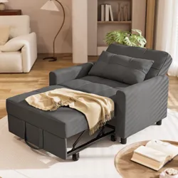 A dark gray chair with a pull-out ottoman, cushioned and accented with a beige throw, sits in a cozy living room setting.