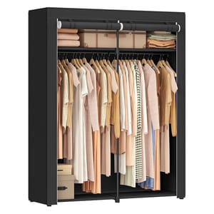 A black fabric wardrobe with two sections, filled with hangers holding beige and pastel clothing. Upper shelves hold folded blankets and storage boxes, with additional boxes at the bottom.