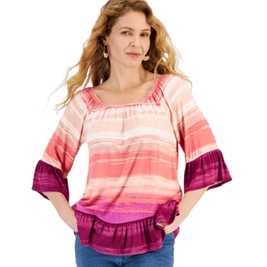 A woman wears a colorful off-shoulder top featuring horizontal stripes in shades of pink, orange, and purple. The top has three-quarter sleeves with ruffled ends and a ruffled hem, paired with blue jeans.