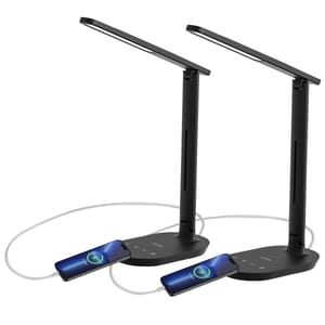 Two black LED desk lamps with adjustable arms and built-in USB ports for charging devices are connected to smartphones via charging cables.