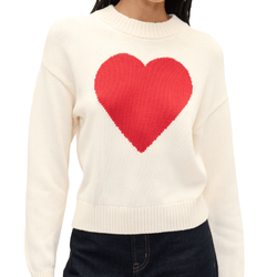 White sweater featuring a large red heart design on the front, worn by a person with dark jeans.