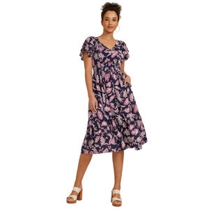 Navy blue floral midi dress with pink and white floral patterns, featuring flutter sleeves, a V-neckline, and side pockets. The dress is paired with tan platform sandals.