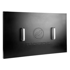 The Blackstone 36\“ Griddle Hard Cover is a sleek, black metal cover featuring the Blackstone logo with two sturdy handles. It provides protection for the griddle surface when not in use.