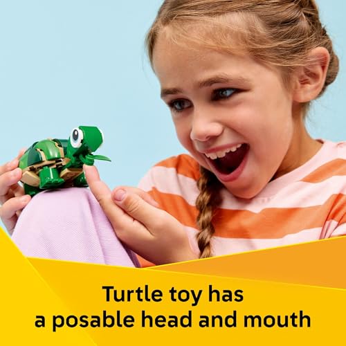 A child is holding a small turtle toy with a posable head and mouth.