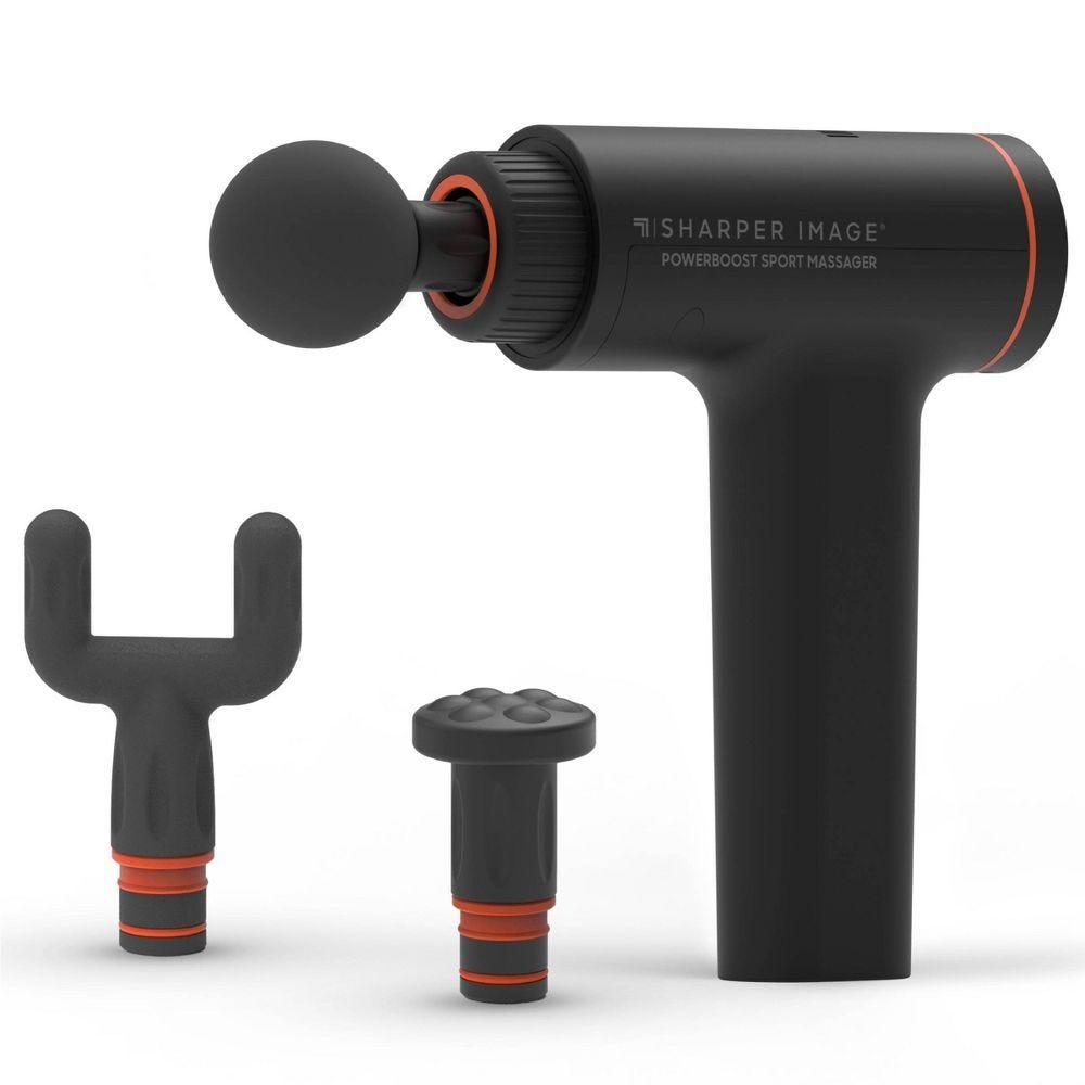 A black Sharper Image Powerboost Sport Massager with interchangeable heads: a round ball, a U-shaped fork, and a flat disc.