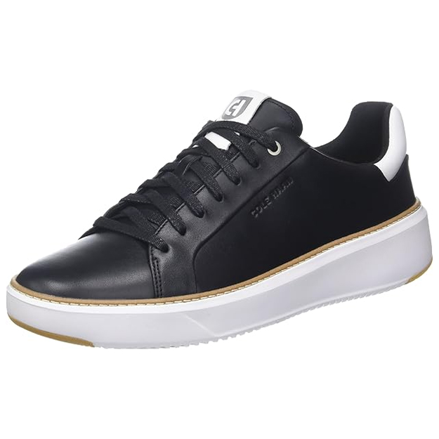 The Cole Haan Grandpro Topspin Sneaker for men features a sleek black leather upper with white detailing, lace-up closure, and a lightweight white sole. Embossed branding adds a subtle touch.