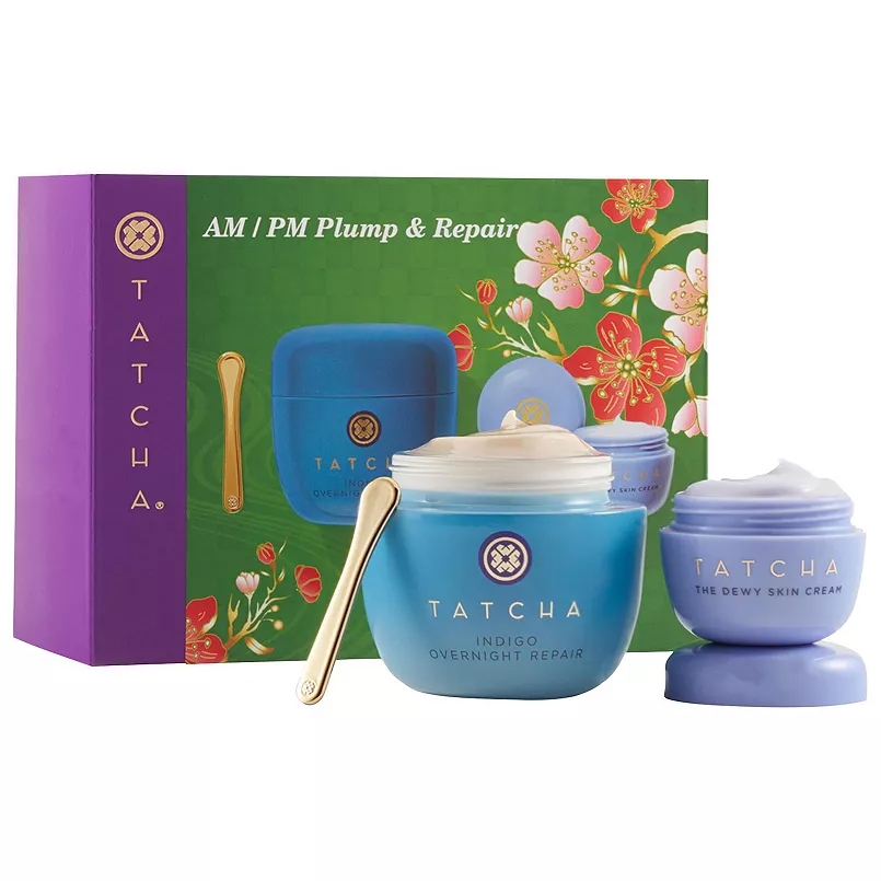 Tatcha Plump & Repair Moisturizer Duo includes Indigo Overnight Repair cream and The Dewy Skin Cream. The set features a purple and green box with floral designs, containing a jar of each cream and a gold applicator.
