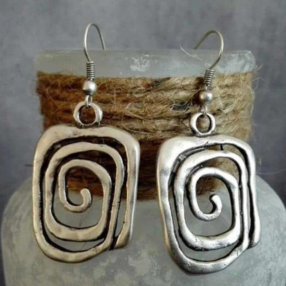 A pair of square spiral-designed silver earrings.