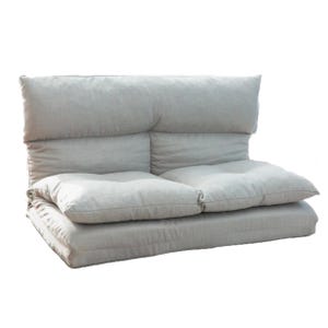 An adjustable flip floor sofa with plush cushions and a soft, neutral fabric. It can be configured for seating or lounging, offering versatility for different comfort needs.