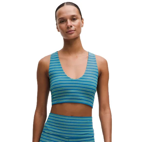A woman is wearing a blue and yellow striped sports bra and matching leggings.