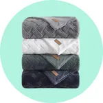 Stack of four plush, textured blankets in gray, white, green, and navy, each with a brown label.
