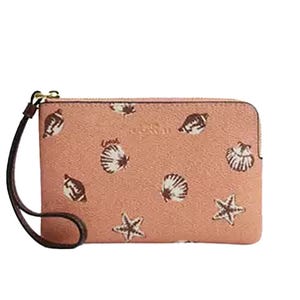 Pink wristlet with seashell and starfish patterns, featuring a zip closure and wrist strap.