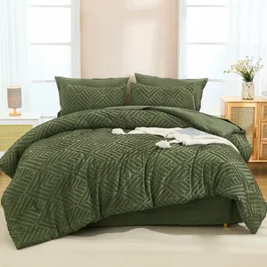 Green geometric-patterned comforter set with matching pillow shams on a bed, featuring a white lamp and floral arrangement on side tables.