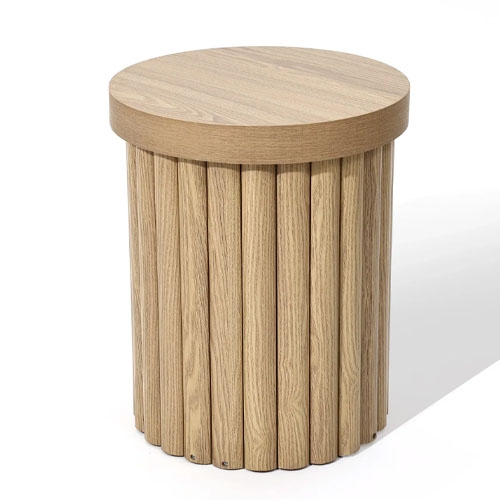 A round wooden side table features a cylindrical base with vertical slats and a smooth top surface.