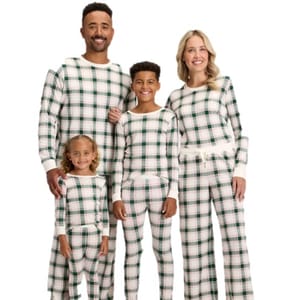 A family of four is wearing matching plaid pajamas with green and white patterns.