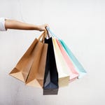 A person is holding several colorful shopping bags.