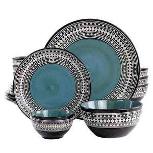 A set of teal and black ceramic dinnerware with decorative geometric rim patterns, including plates and bowls.