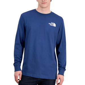 A person wears a blue long-sleeve The North Face t-shirt with a small white logo on the chest, paired with dark jeans.