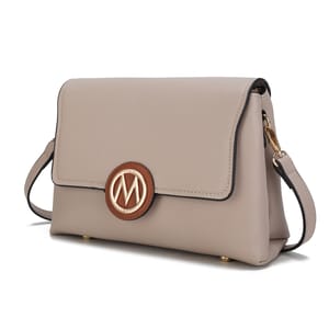 A beige handbag with a flap closure, featuring a circular emblem with an \“M\“ logo, and an adjustable strap.