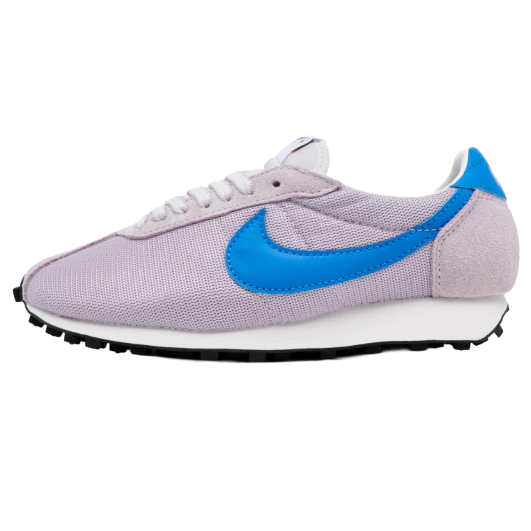 A lilac and blue sneaker with a prominent blue swoosh logo on the side, featuring a suede and mesh upper and a black rubber outsole.