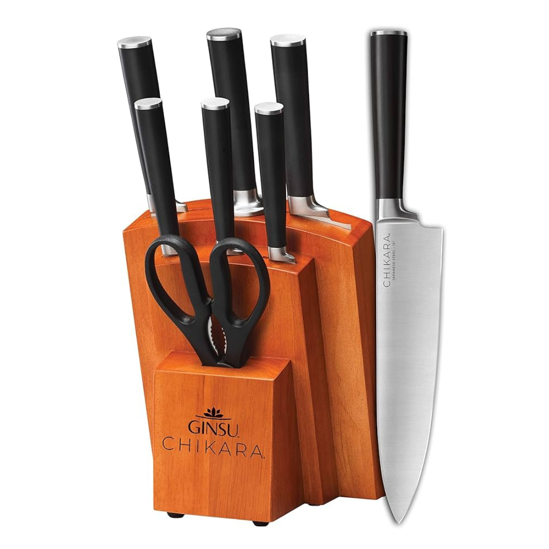 Ginsu Chikara knife set with black handles includes several knives, a pair of scissors, and a wooden block for storage.
